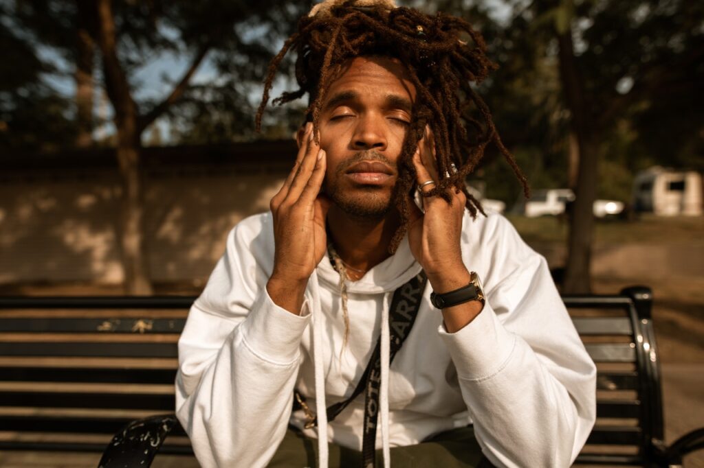 Black man contemplating, sitting on bench