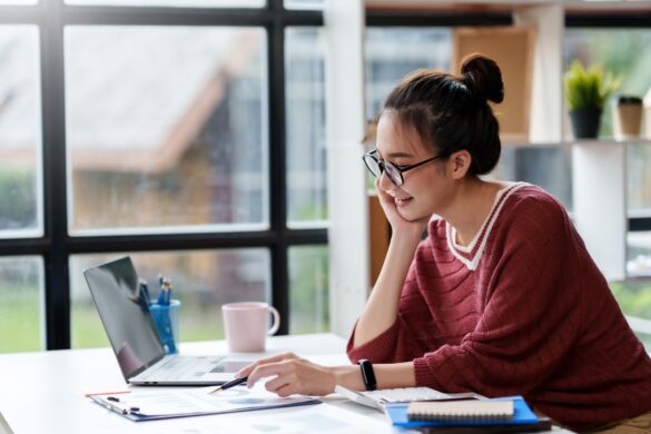 Beautiful Asian businesswoman is contemplating new ideas for her work with a bright and happy face.