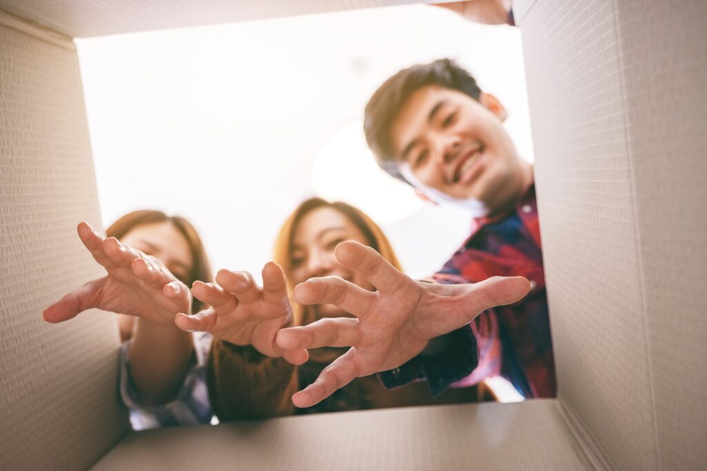 Group of young people opening and grabbing a gift in the box