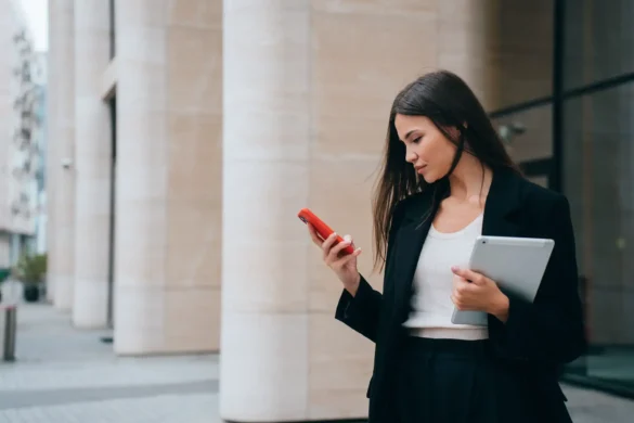 successful girl, lawyer stands outside courthouse, reads messages on phone, holds tablet and studies