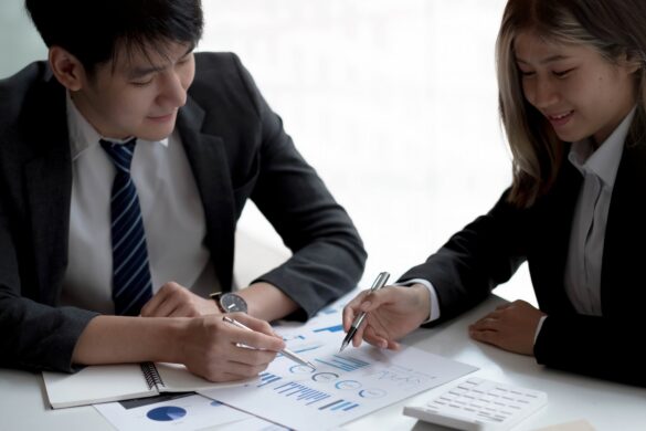 Business people meeting to find analytical ideas pointing to the graph at the office.