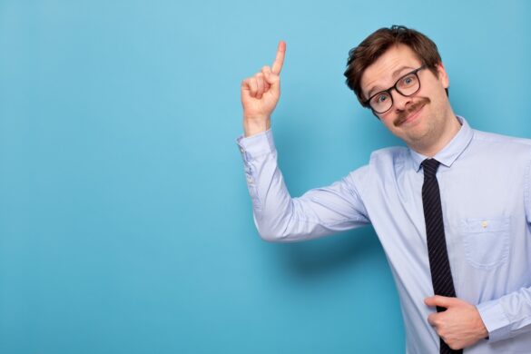 Satisfied young man in glasses showing index finger up