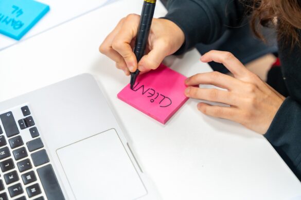 Writing into a adhesive note during brainstorming meeting