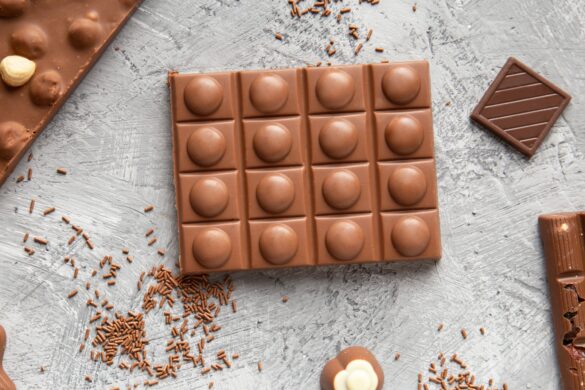 Milk chocolate bars and candies on a gray background top view.